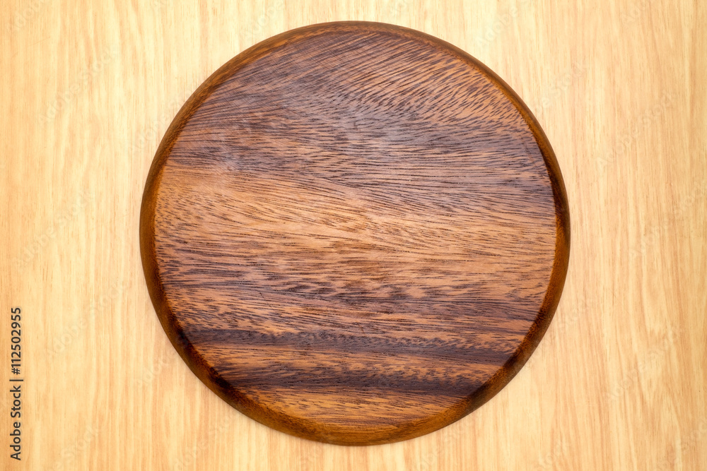 Top view of dark brown round wooden chopping block on light wood Top view of dark brown round wooden chopping block on light wood
