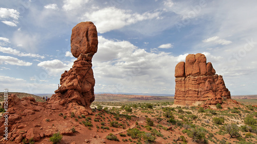 Balanced Rock on a marbled sky background with sandstone towers in the foreground, Arches National Park, Utah