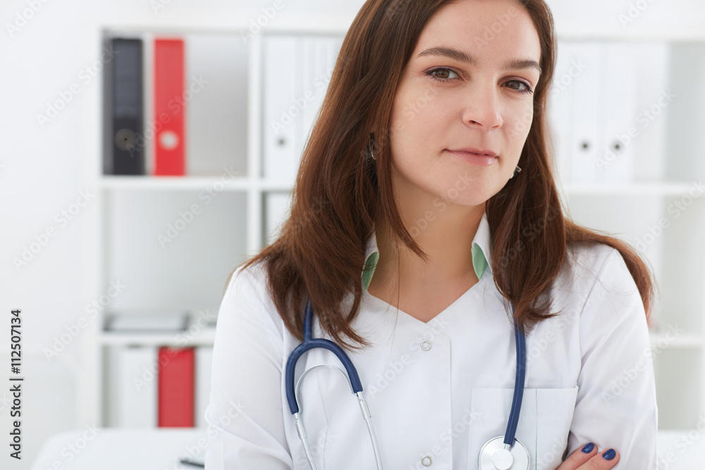 Beautiful female medicine doctor hands crossed on her chest. She smile and look in camera. Medical care or insurance concept. Beautiful female medicine doctor hands crossed on her chest. She smile and look in camera. Medical care or insurance concept.
