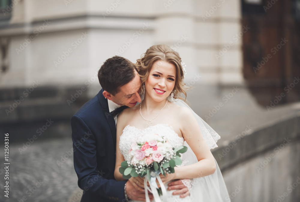 wedding couple is standing and kissing in the streets of old city wedding couple is standing and kissing in the streets of old city
