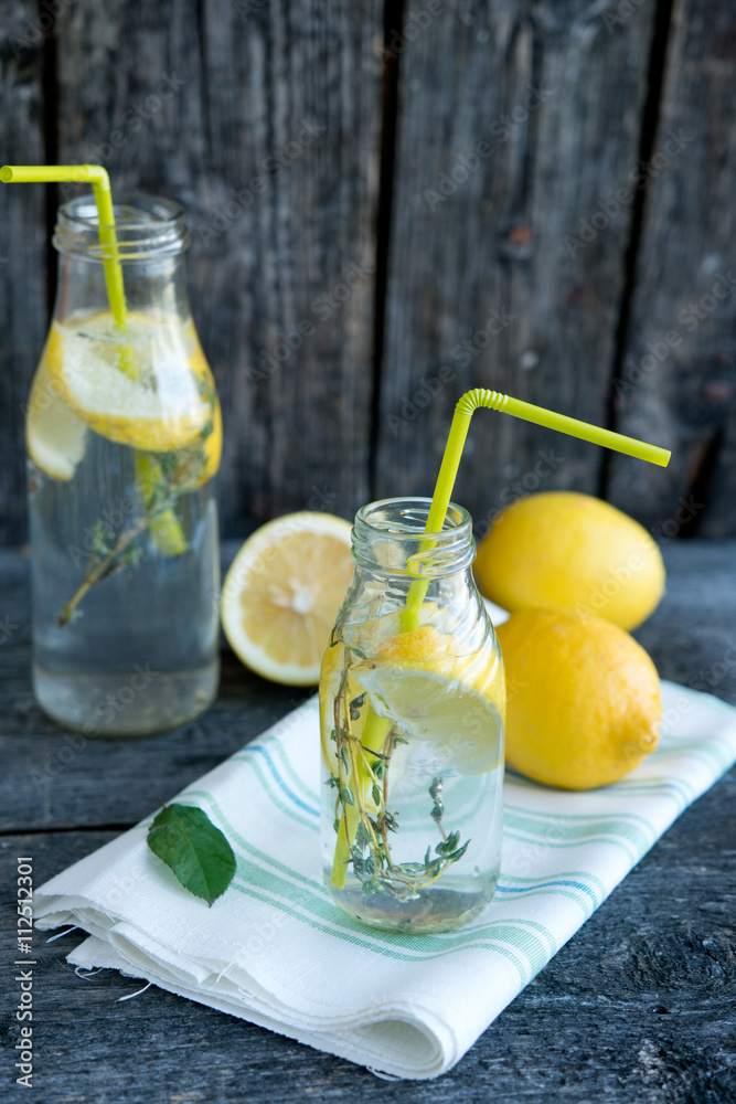 Fototapeta premium Cold refreshing lemonade with lemons and a thyme 