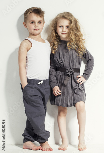 Funny lovely children. Fashionable little boy and girl in grey and white clothes and barefoot. stylish kids in casual clothes with different emotions. fashion children