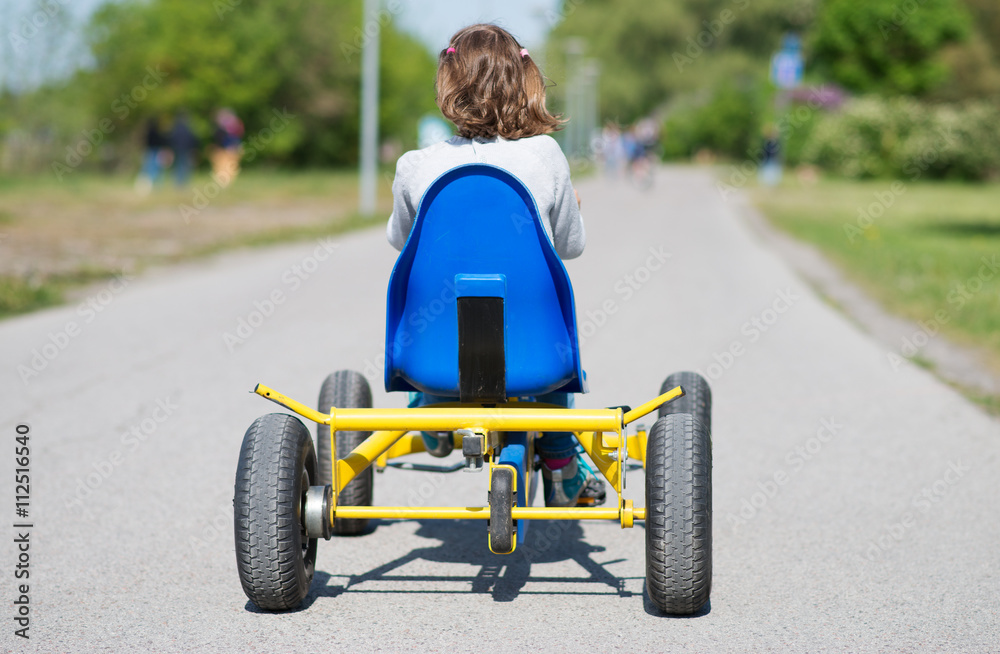 Little girl riding on pedal karting. Little girl riding on pedal karting.