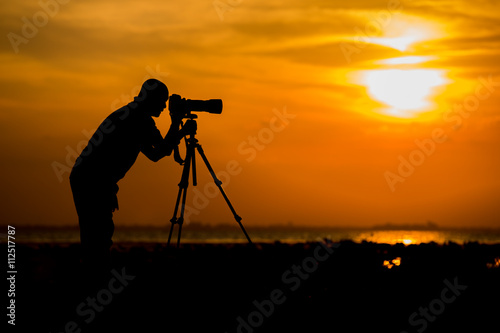 photographer silhouette with sunset or sunrise
