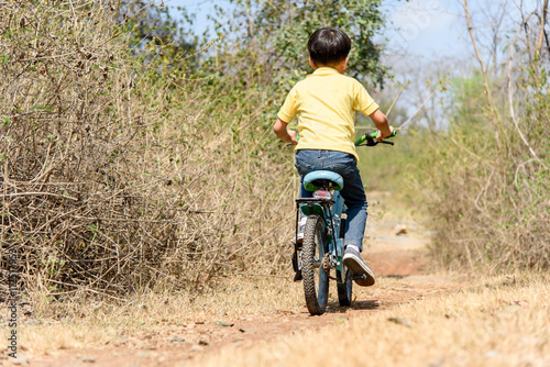 Little boy ride bicycle on the rock road. © TinPong