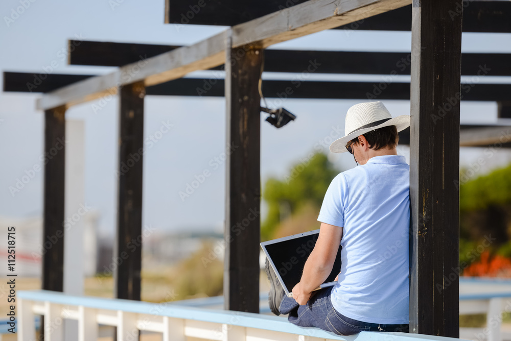 Businessman enjoying working outside with laptop, talking on phone Businessman enjoying working outside with laptop, talking on phone