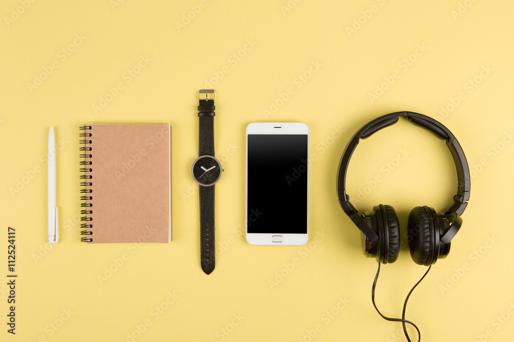 Smartphone, notepad, headphones, pen and watch on the color back Smartphone, notepad, headphones, pen and watch on the color back