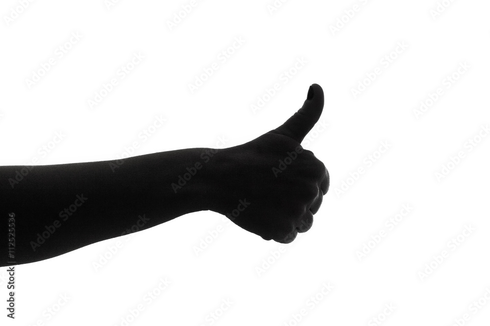 A hand giving the thumb-up gesture. Silhouette shot. A hand giving the thumb-up gesture. Silhouette shot.
