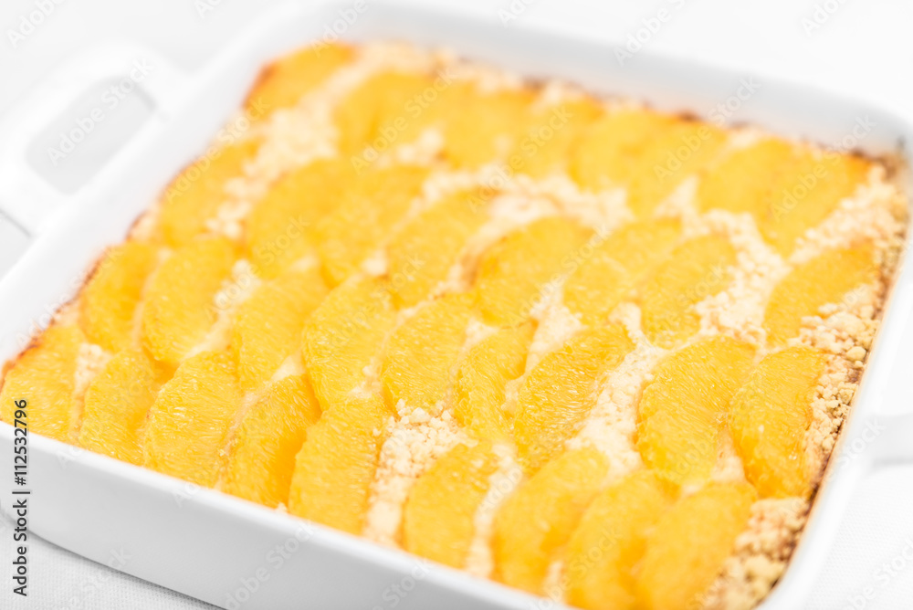 Pie with oranges in the baking dish on a white table Pie with oranges in the baking dish on a white table