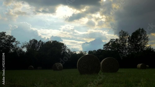 timelaps di un temporale seralein arrivo su campo con covoni di fieno photo