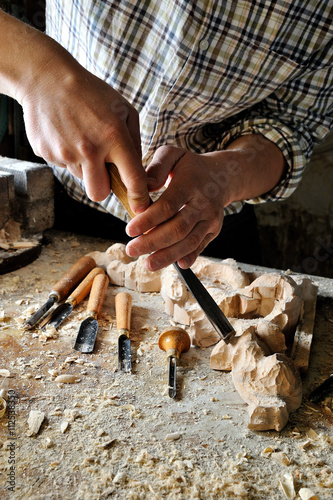 carver in workshop carving with chisel