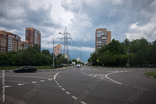 Thunderclouds over houses, road and high-voltage tower in the city of Moscow