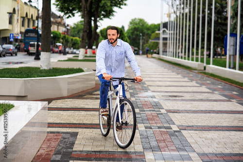 young hipster man with fixed gear bike on city street