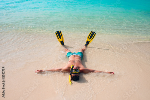 Man, relaxing in yellow black flippers fins and mask.
