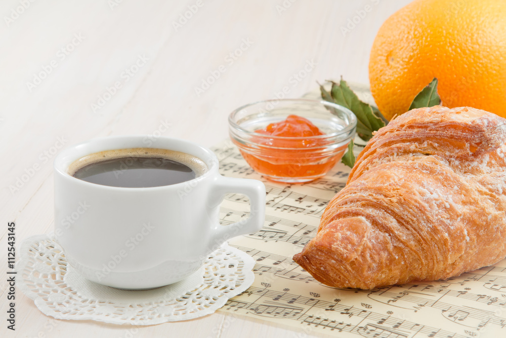 A cup of black coffee, croissant. French breakfas