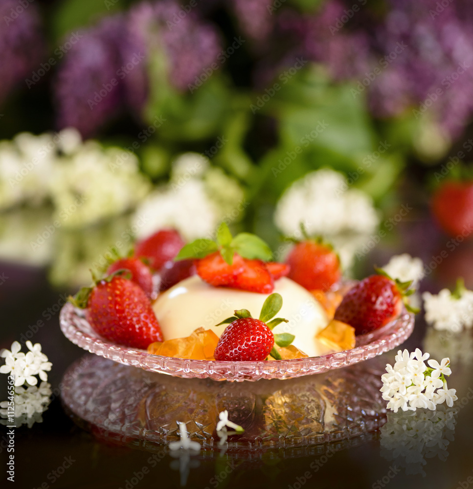 Spring Italian dessert pannacotta with strawberries and flowers