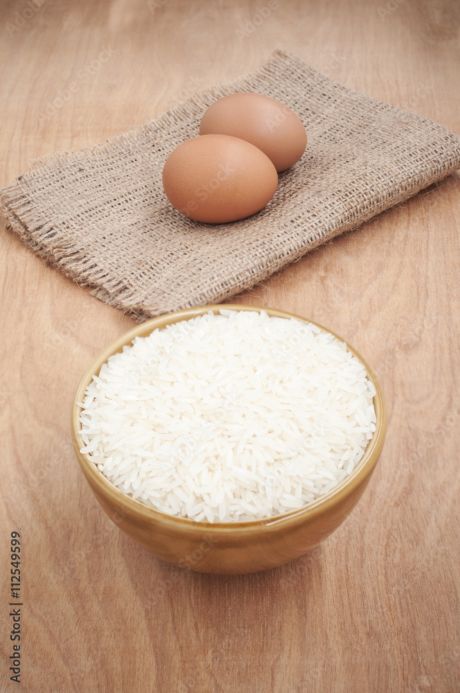 White rice in brown bowl with egg on wooden