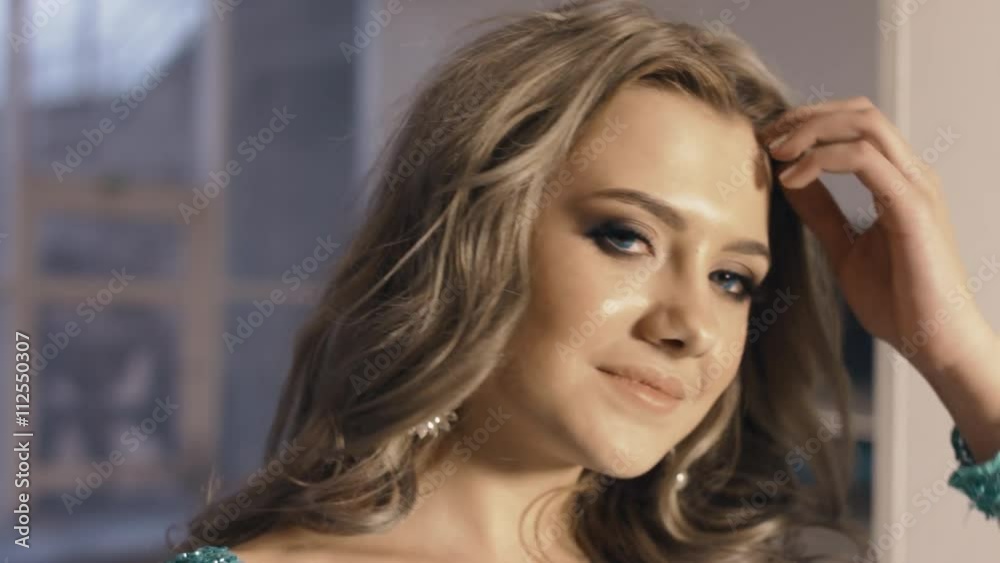 Gorgeous blue-eyed model with curly hair posing in the studio Gorgeous blue-eyed model with curly hair posing in the studio