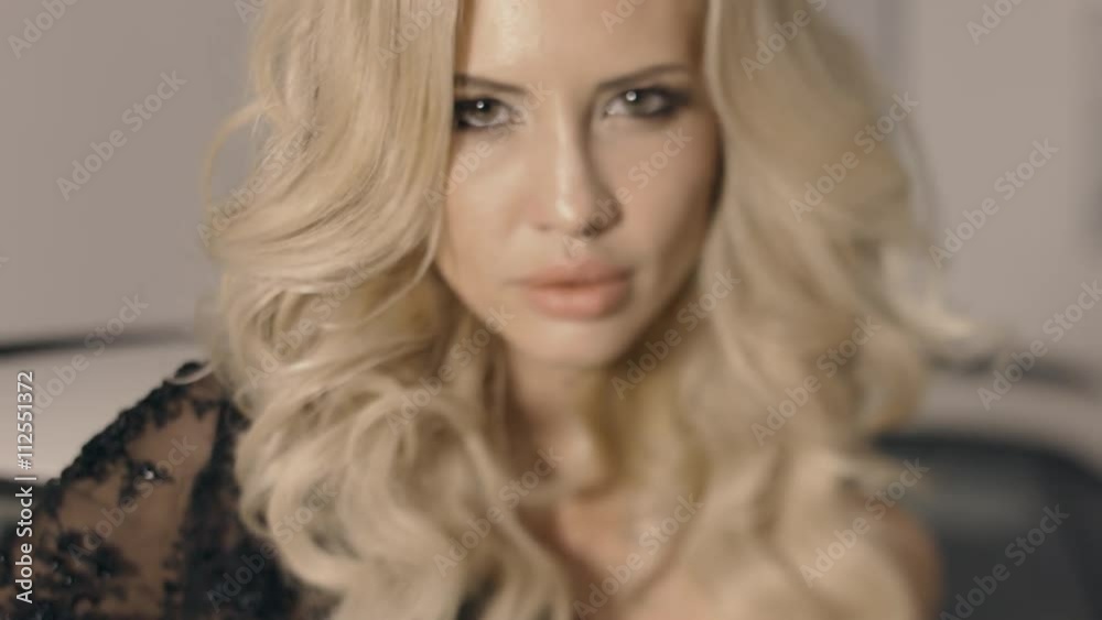 Stunning blonde posing near the car in the showroom Stunning blonde posing near the car in the showroom