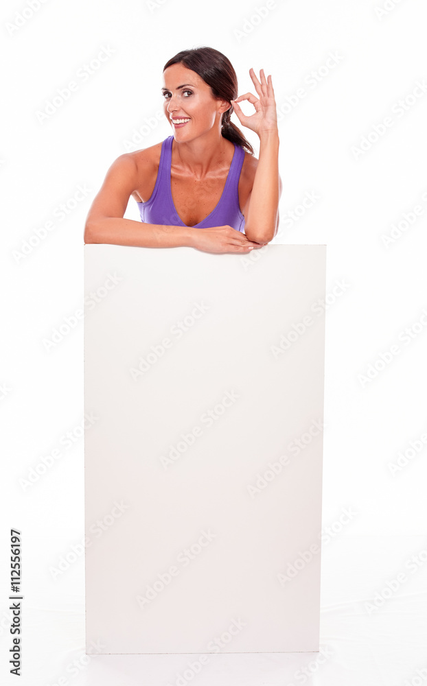 Healthy smiling brunette behind blank placard