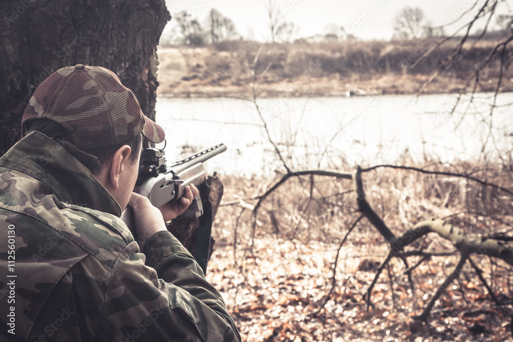 Φωτογραφία Hunter man with gun aiming and prepared to make a shot during hunt