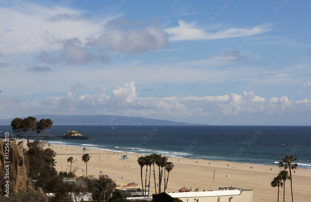 Amusement Park on the Pacific ocean, the beach landscape. The ocean, beach and blue sky in USA, Santa Monica. The ocean and waves during strong winds.