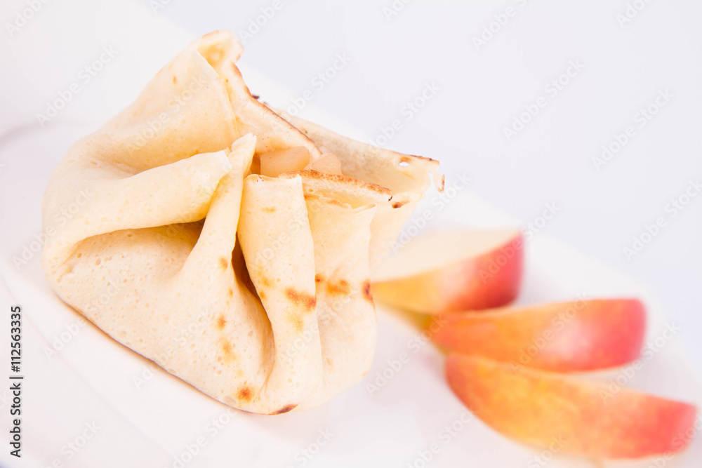 Pancake sack stuffed with braised apples decorated with apple slices Pancake sack stuffed with braised apples decorated with apple slices