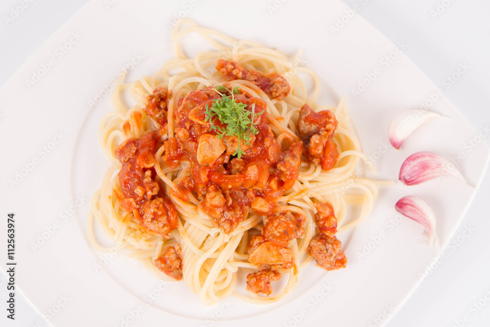Spaghetti bolognese on a plate decorated with garlic cloves and cress Spaghetti bolognese on a plate decorated with garlic cloves and cress