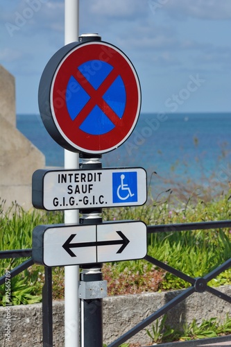 Panneau de signalisation routière indiquant une place réservée aux handicapés photo