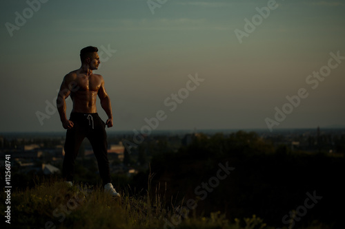 Sexy muscular man on sky background