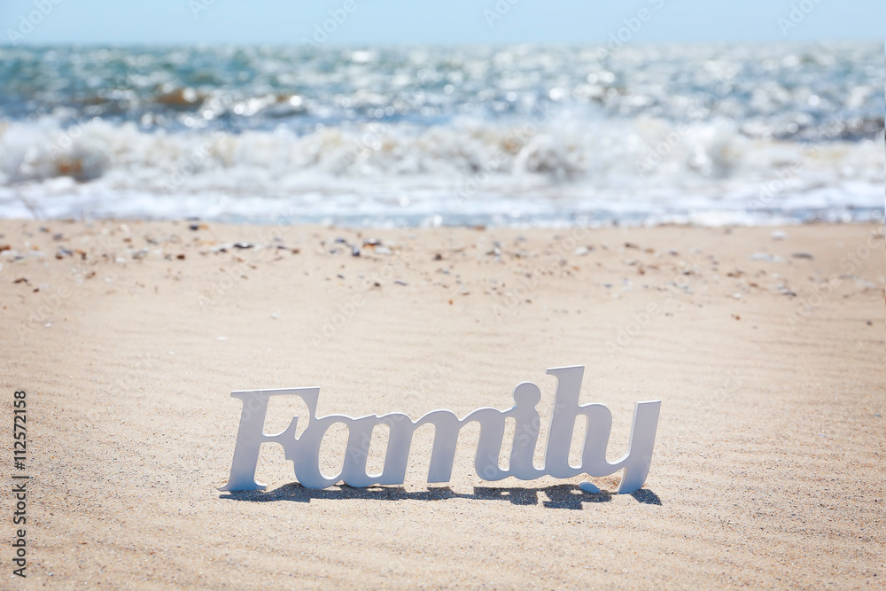 Fototapeta premium Word family on a sand, close up