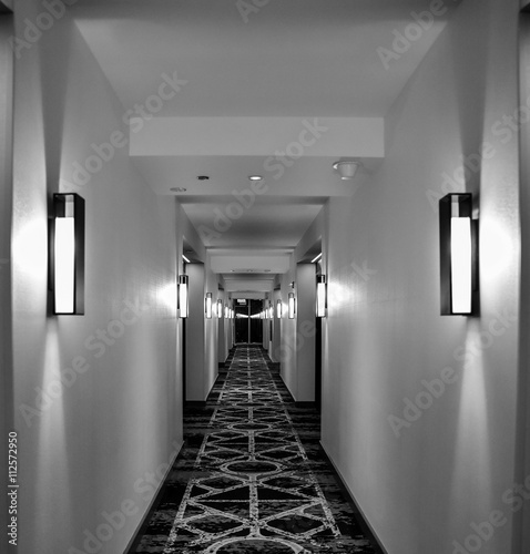 Long hallway with side light sconces appearing infinite