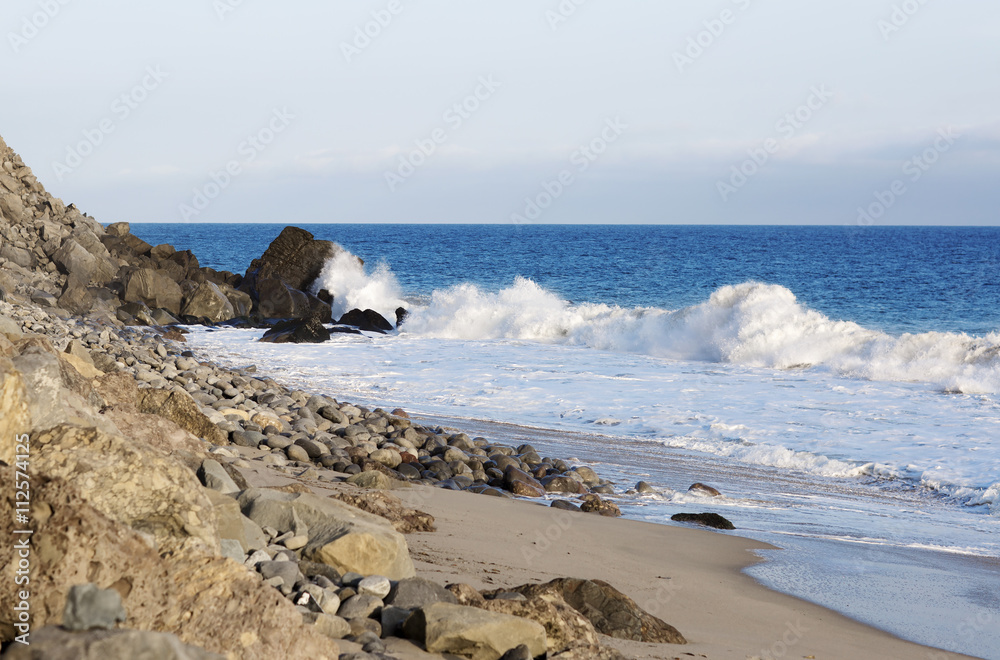 Beach landscape in Malibu. The ocean and waves during strong winds in United States, California. Waves breaking on the rocks.