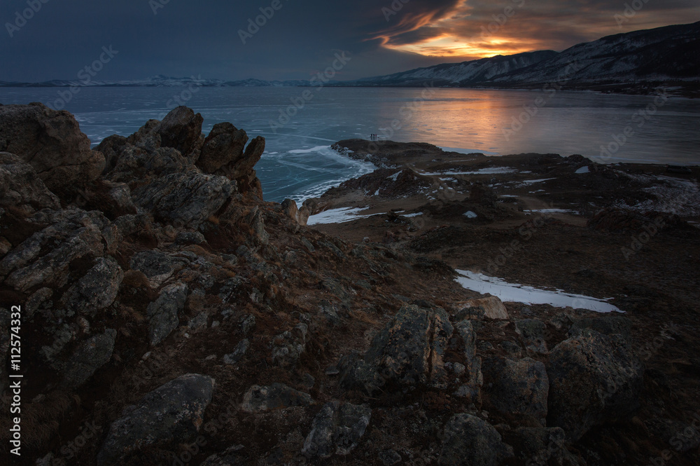 Rocks above frozen Baikal lake at the sunrise