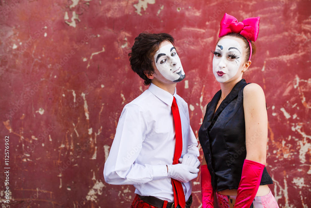 Obraz premium Couple mimes cute pose in front of a red wall.