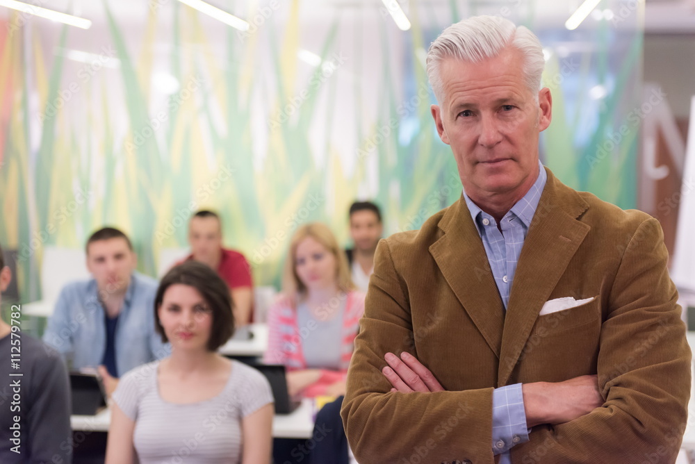 portrait of  teacher with students group in background