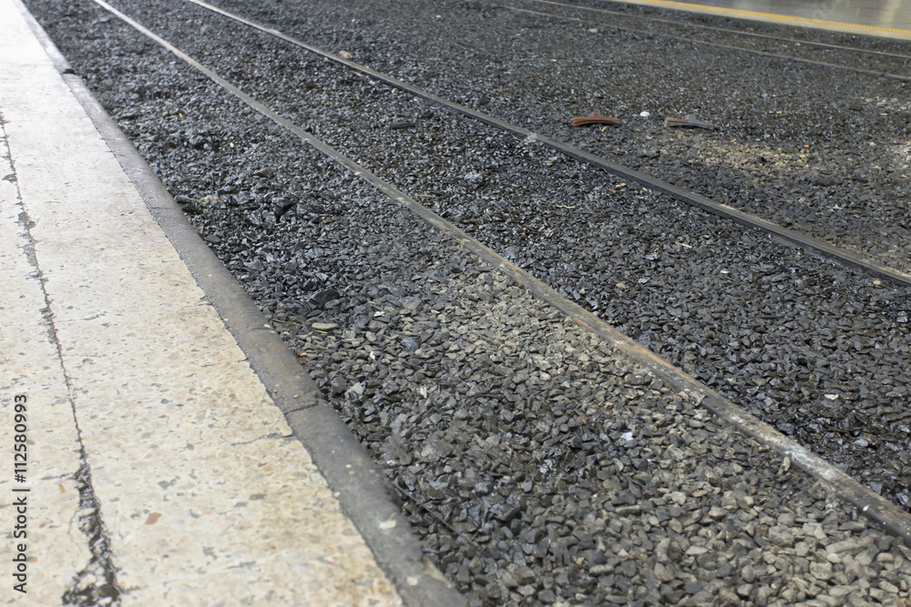 Obraz premium Oblique view of railway and footpath in train station.