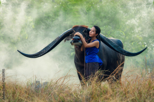 Thai young woman farmer with buffalo