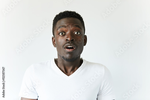 Portrait of shocked dark-skinned student or employee in casual clothes, looking at the camera with surprised expression, astonished with some unexpected news, mouth wide open. Body language