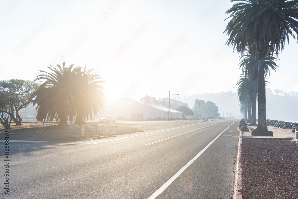 Fototapeta premium rural empty asphalt road near water at sunrise in san francisco