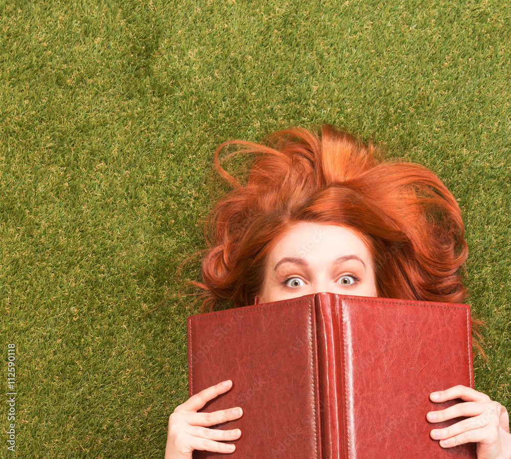 Fotografie Student girl lying with notebook and looking at camera