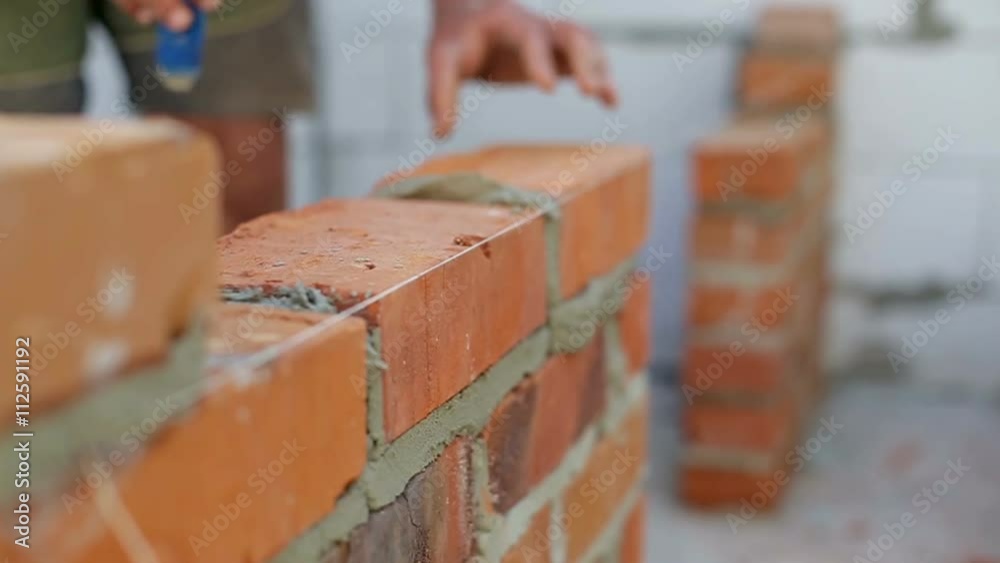 Work lays bricks on a construction site