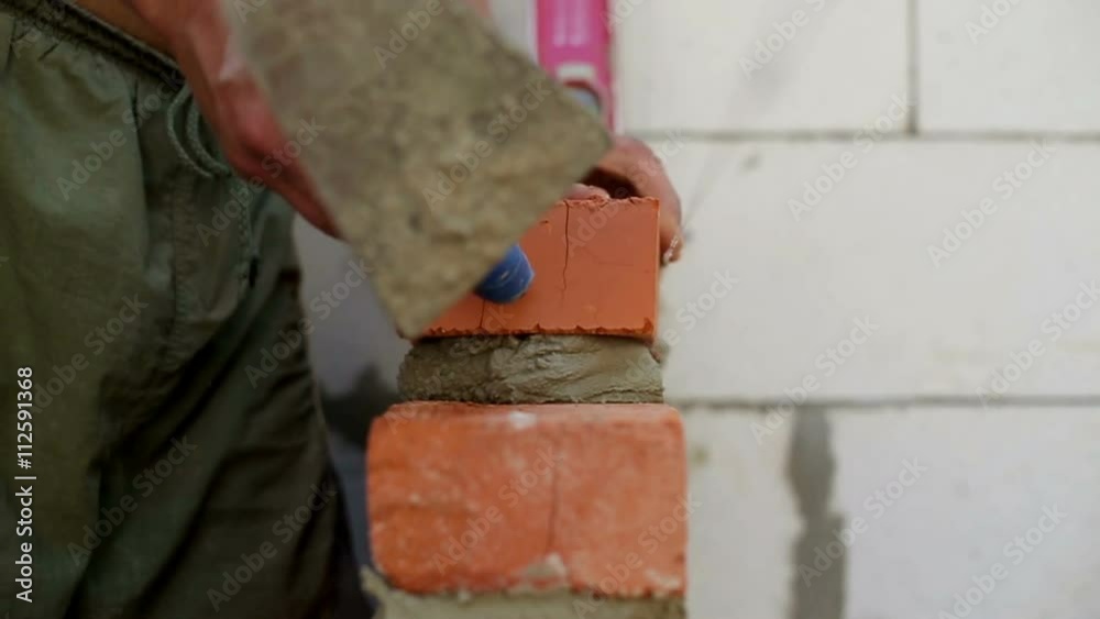 Work lays bricks on a construction site Work lays bricks on a construction site