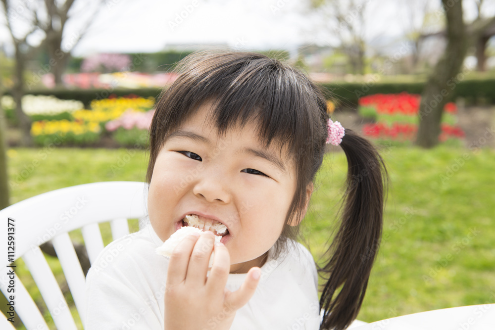 公園でサンドイッチを食べる女の子