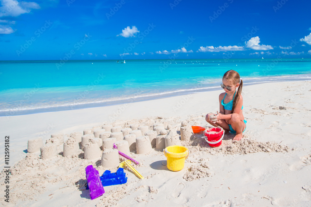 Adorable kid playing with beach toys on white beach