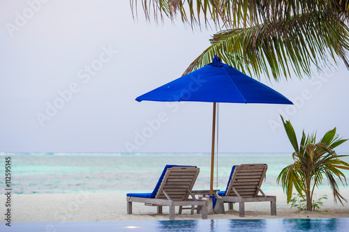 Sunbeds and umbrella at beautiful tropical resort
