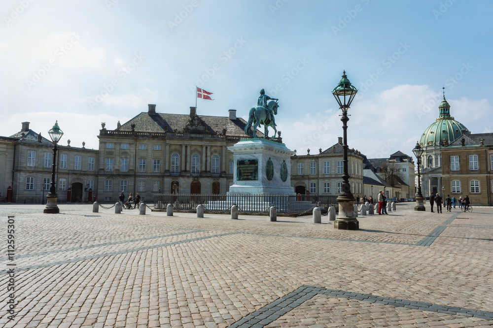 Beautiful old buildings of Amalienborg castle with the equestrian statue in Copenhagen city center at summer day, Denmark.