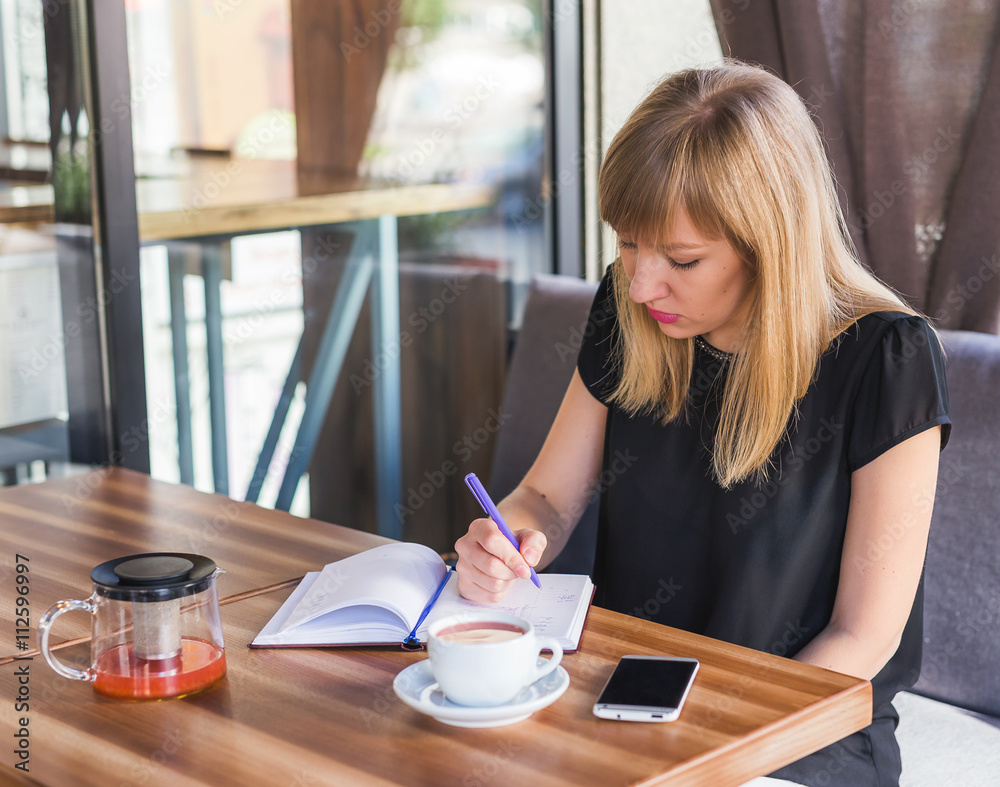 woman drinking tea and working with business papers woman drinking tea and working with business papers