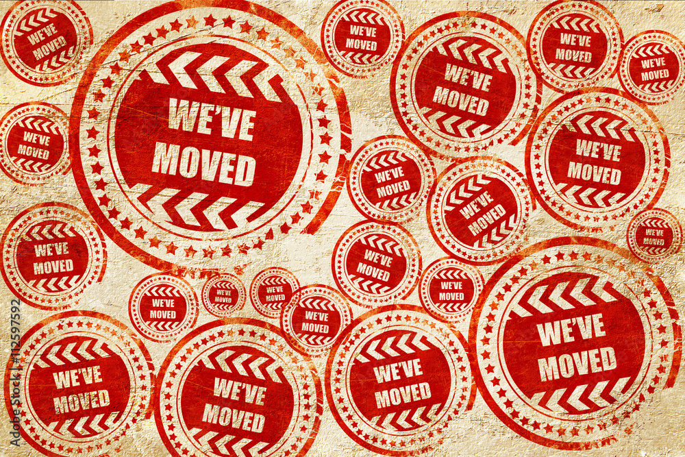 Fototapeta premium We've moved sign, red stamp on a grunge paper texture