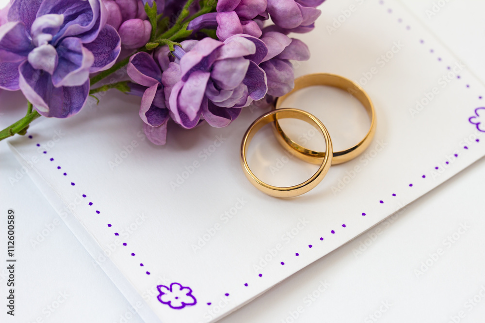 Wedding rings, invitation and flowers of lilac. Wedding rings, invitation and flowers of lilac.